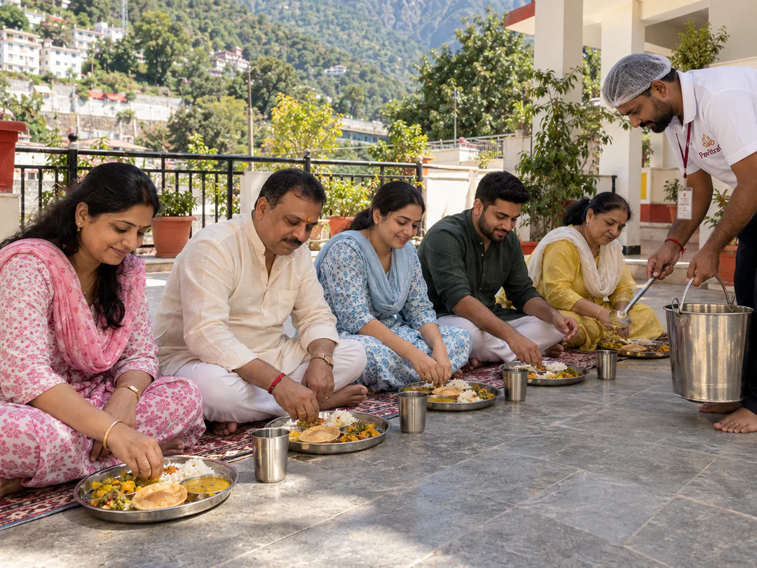 A family seated for a thali meal while a sevadar serves, with the hills behind