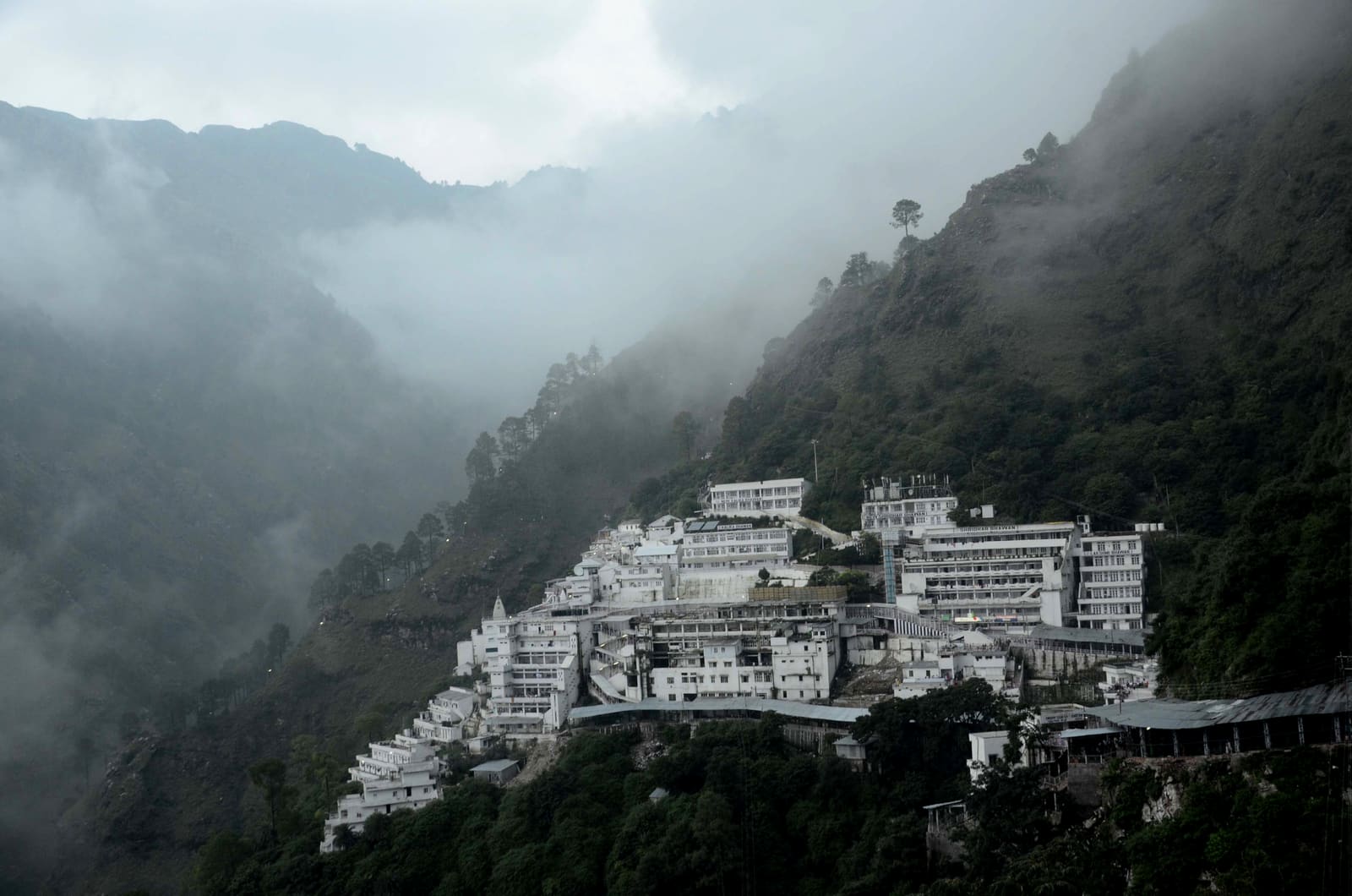 The Mata Vaishno Devi Bhawan complex on the Trikuta hills, surrounded by monsoon clouds
